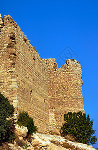 中世纪武士堡垒的废墟古董岩石城堡石头植物衬套天空建筑窗户图片