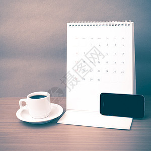 咖啡杯 电话和日历工作白色桌子办公室笔记本写作笔记商业杯子铅笔背景图片