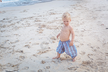 托德勒在海滩上行走光线海洋婴儿儿童人类假期脚印手臂旅游赤脚图片
