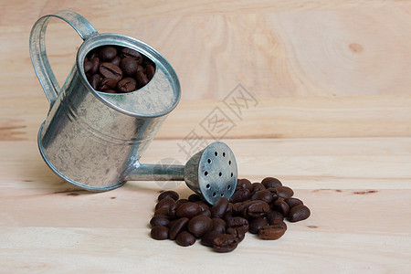水罐微型和咖啡豆木质背景地面公司咖啡咖啡厂咖啡馆桌子宏观烘烤喷壶咖啡树图片