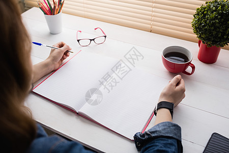 在办公桌工作的临时工商业妇女职场铅笔眼镜旋转职业咖啡智能饮料红砖办公室图片