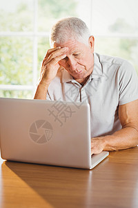 使用膝上型电脑的老年男子男人窗户岁月家庭技术住所闲暇家庭生活客厅男性图片