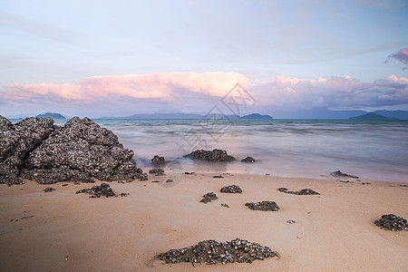 傍晚海滩附近的石块地平线天空蓝色海景海岸场景日落岩石热带旅行图片