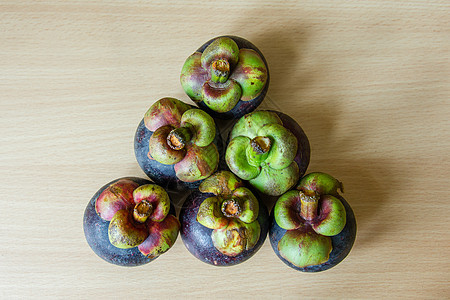 餐桌上的芒果桌子紫色气候水果热带绿色饮食美食木头山竹背景图片