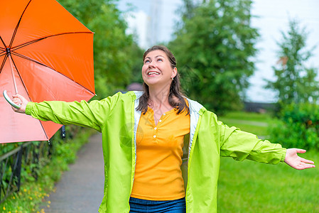 快乐的年轻女士 享受公园中夏雨图片