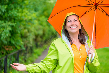 一个美丽的女孩的肖像 带着雨伞和雨衣图片