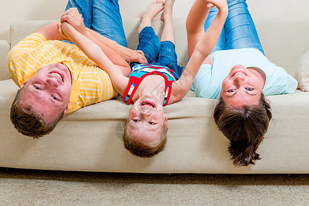 在客厅沙发上有一个孩子的幸福家庭图片
