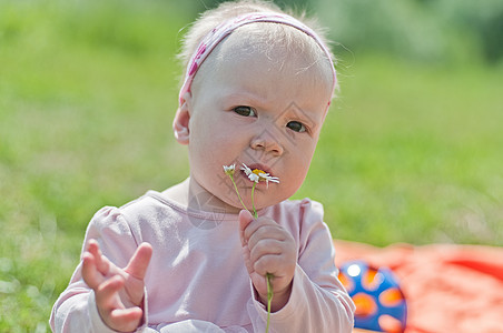 带着花的小女孩的肖像孩子粉色绿色女性女士白色婴儿童年玩具快乐图片