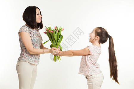 女孩给母亲一束花家庭孩子们郁金香青少年花朵微笑成人礼物孩子庆典图片