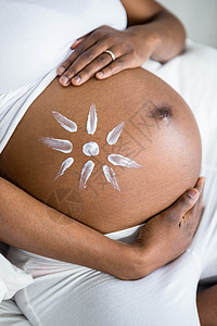 孕妇在肚子上涂奶油棉被黑色太阳按摩绘画坐垫家庭生活闲暇房子腹部图片