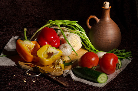 烹饪用新鲜蔬菜砧板黄色洋葱黄瓜厨房黑色背景绿色营养沙拉图片