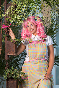 穿着粉红色假发的小女孩 在公园里装扮成绿色美丽扮演青少年文化头发闲暇裙子妻子花园图片
