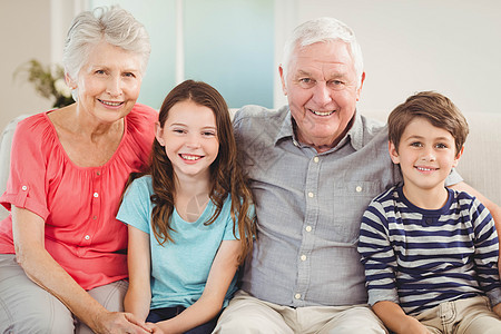 祖父母和孙孙辈一起坐在沙发上老年微笑孙女女士房子老年人闲暇家庭生活快乐男性图片