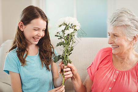 外婆给孙女送了几束鲜花客厅家庭女士祖母乐趣老年人女孩亲密感公寓感情图片