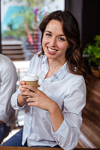 微笑的女人拿着咖啡喝着一杯咖啡上段食堂店铺服务杯子商业咖啡馆饮料咖啡店零售背景图片