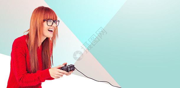 笑笑的时装女玩电子游戏综合图像游戏快乐女性针织品微笑安慰乐趣蓝色按钮边缘图片