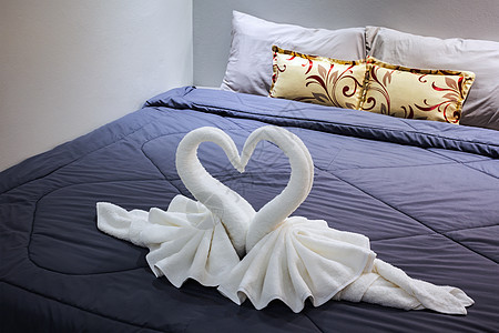 在床单上折叠成天鹅形的毛巾身体健康奢华生活花朵纺织品呵护织物卫生烛光图片