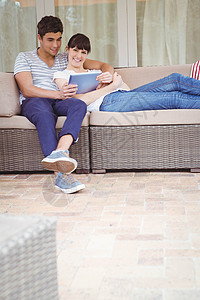 使用数字平板电脑的年轻夫妇休闲微笑服装夫妻家庭生活家庭快乐技术男性触摸屏图片