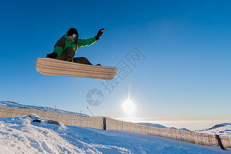 跳跃时滑雪者度假村粉末娱乐木板下坡滑雪旅行滑雪板夹克太阳图片