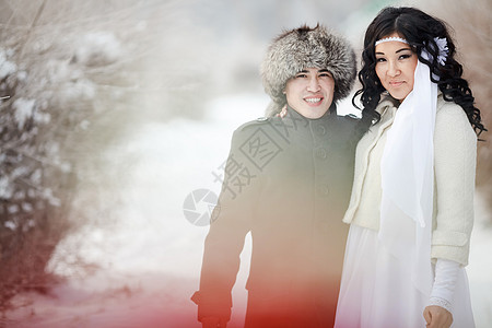 冬季婚礼 异国情调的亚洲新婚夫妇 戴着裘皮帽的新郎 穿着冬衣的新娘图片