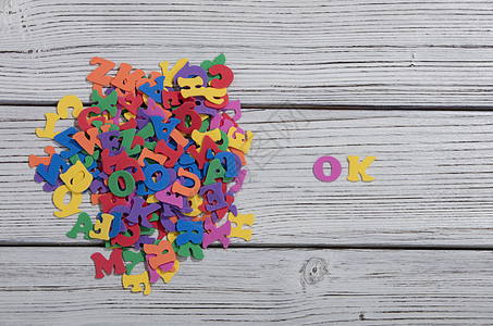 在白木板上用彩色字母写成的多彩单词语言社会字体艺术木头玩具刻字打字稿拼写标签图片
