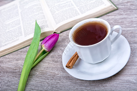 一杯加肉桂和紫郁金香的茶杯子棕色木头活力粉色作品图片