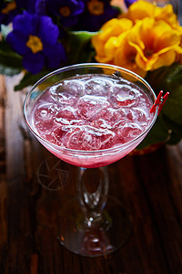 粉红果汁木制桌上有冰的盛装鸡尾酒桌子热带果汁饮料酒精咖啡店玻璃派对水果酒吧背景