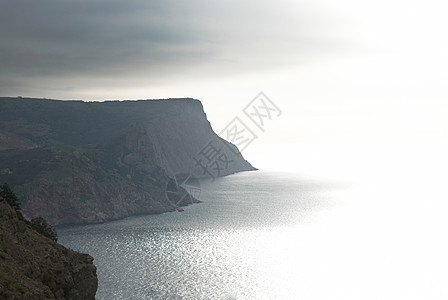 平静的海景与风暴般的天空地平线蓝色天气岩石旅行射线季节悬崖阳光热带图片