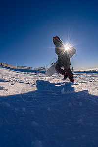 滑雪运动员在蓝天上行走太阳冒险国家远足登山者旅行活动男生滑雪板森林图片