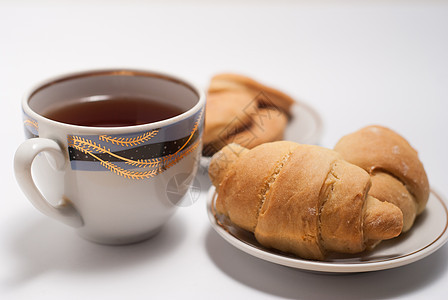 一杯茶 配有模式和新鲜羊角面包饮料食物白色液体早餐图片