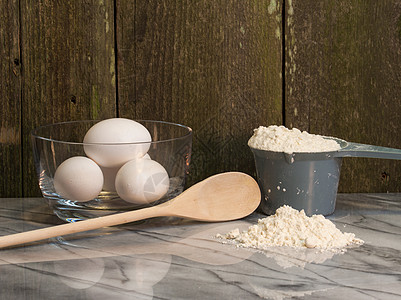 大米面粉用于家庭烹饪和烘烤的鸡蛋团体早餐木头大理石桌子厨房国家蛋壳农场食物背景
