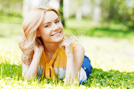 草地上的年轻女子成人说谎女孩场地喜悦绿色乐趣公园自由金发图片