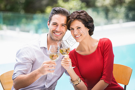 微笑的情侣烤白葡萄酒的肖像图片