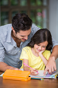 快乐的父亲帮助女儿做家庭作业图片