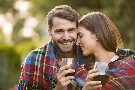 带着被毯子包着葡萄酒的年轻夫妇图片