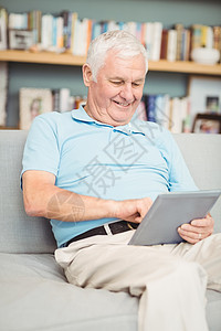 使用数字平板电脑微笑的老年人图片