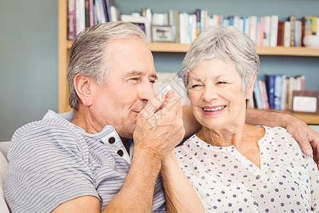 年长男子坐在家中亲吻妻子的手图片