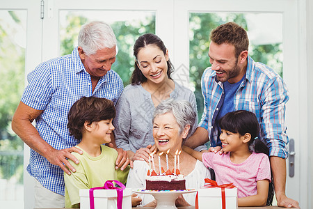 生日晚会期间与祖父母一起微笑的家庭图片