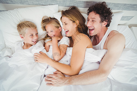 笑笑家庭在床上享受的高度角度视角图片