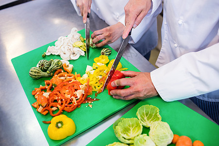 切除蔬菜厨师的特写同事职业商业切菜板女士烹饪合作制服工作服务图片