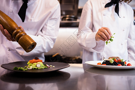 两位厨师在柜台上烧饭食物职业准备厨房制服工人装潢男人商业伙伴图片