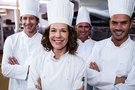 一群快乐的厨师对着镜头微笑餐厅餐饮职业团体酒店手臂男性女性白人男人图片