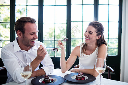 情侣互相喂养并微笑夫妻勺子男性快乐酒精感情酒杯用餐甜点女性图片