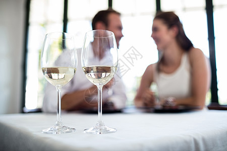 两杯葡萄酒和一对情侣相近闲暇酒杯女士女性玻璃夫妻桌子茶点享受酒店图片