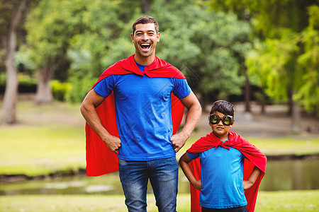 父亲和儿子穿着超级英雄服装快乐想像力家庭男性俏皮身份眼镜斗篷孩子红毯子图片
