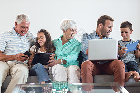 幸福的家庭坐在沙发上冲浪祖父客厅电脑互动技术触摸屏房子亲密感孙女图片