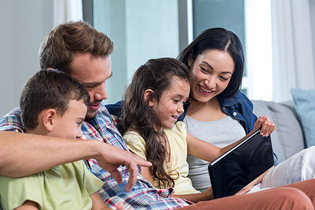 父母与儿子和女儿坐在一起 看数字平板电脑姐姐女性滚动服装客厅公寓住所房子感情触摸屏图片