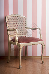 压粉色条纹墙的旧椅子图片
