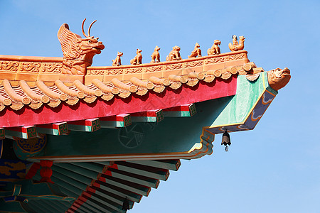 泰国传统中国寺庙 装饰着神话怪兽的传说木头瓷砖数字屋檐恶魔雕像天空建筑艺术蓝色图片