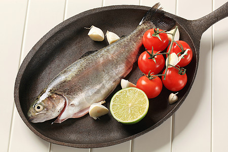 新鲜的鳟鱼在铸铁棍子上平底锅用具健康饮食厨房炊具蔬菜食材食物内脏煎锅图片